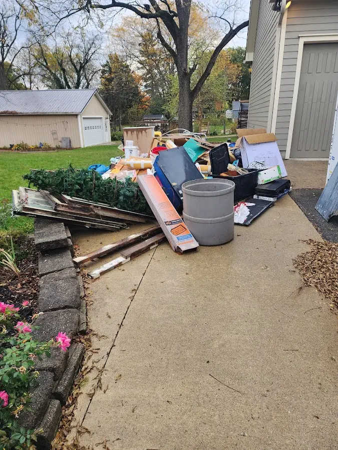 Dumpster being loaded with debris for Roofing Dumpster Rental in Hutchison